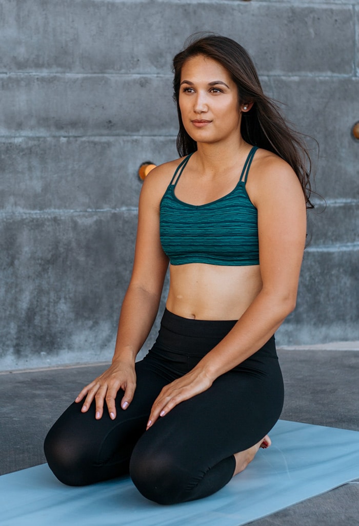 Woman sitting on a yoga mat in workout clothes