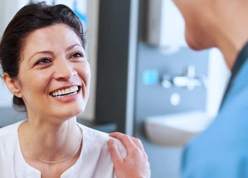 Happy woman talking to her doctor after lesion removal