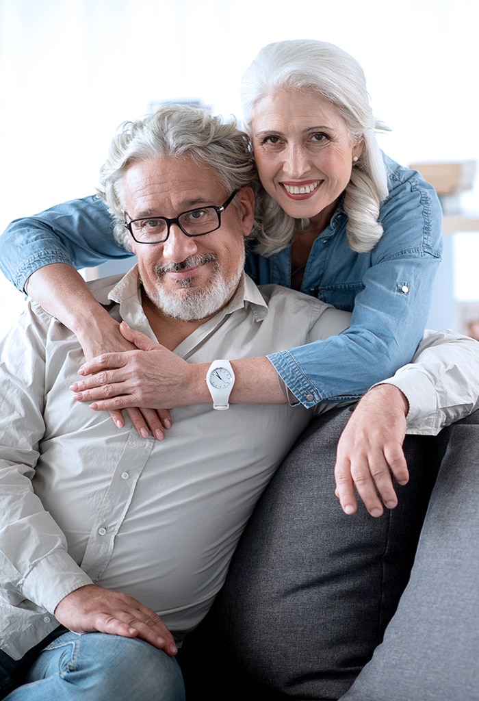 Older couple holding each other in their living room